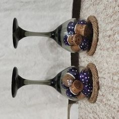 two wine glasses with corks in them are sitting on the floor next to each other