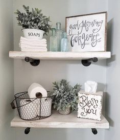 two shelves with toilet paper, plants and other bathroom items on top of each shelf