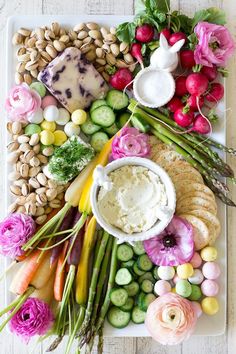 a platter filled with different types of food and flowers on top of each other