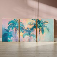 three paintings with palm trees on them in an empty room, one is blue and the other is pink