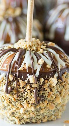 chocolate covered caramel apples on a white plate with candy bars in the back ground