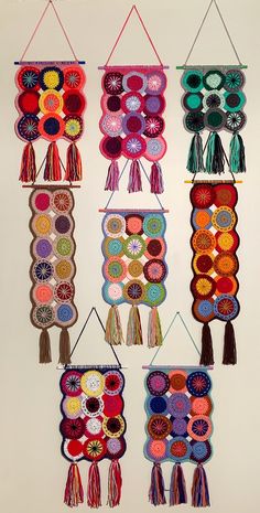 several colorful wall hangings with tassels on them