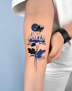 a woman with a blue flower tattoo on her arm