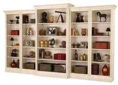 two white bookcases with books and vases on them