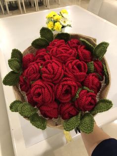 a person holding a bouquet of red roses