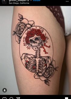 a woman's thigh with a skeleton and roses on it