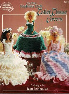 two crocheted dolls sitting next to each other on top of a red table