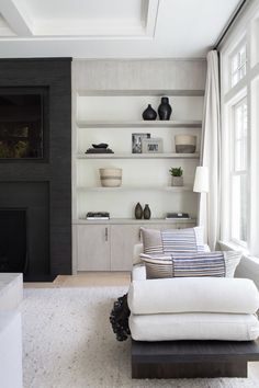 a living room filled with white furniture and bookshelves