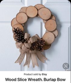 a wreath made out of wood slices and burlap bow hanging on a door