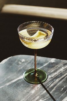 a glass filled with liquid sitting on top of a table