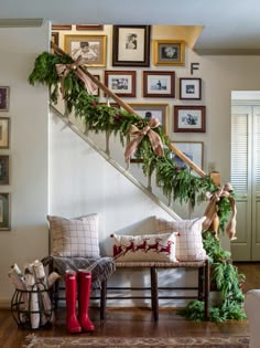 the stairs are decorated with christmas garland and stockings