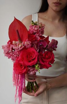 a woman holding a bouquet of flowers in her hands