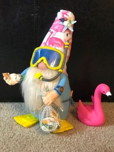 a gnome with goggles and a pink flamingo is next to a plastic bag