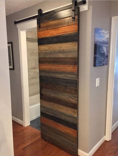 a sliding door made out of wooden planks in a room with hard wood flooring