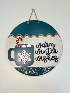 a sign that says warm winter wishes hanging on the wall with a candy cane in it