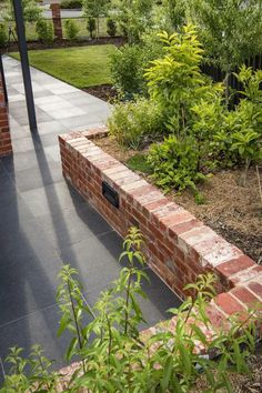 a brick wall in the middle of a garden