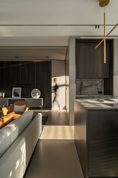 a modern living room and kitchen area with wood paneling, marble counter tops and floor to ceiling windows