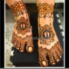 two feet with henna tattoos on them, one has the letter u in it