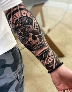 a man's arm with a clock and skull tattoo on it