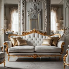 a white couch with gold pillows in front of a large mirror and ornate wall decor