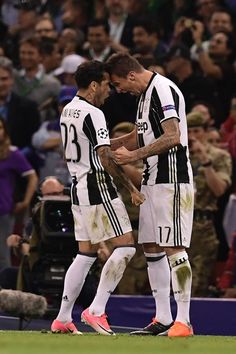 two soccer players congratulate each other in front of an audience at a sporting event