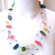 a white mannequin wearing a multicolored necklace on it's neck