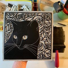 a hand holding up a card with an image of a black cat on it's face