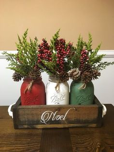 three mason jars filled with berries and pine cones