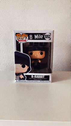 a pop vinyl figure in a box on a counter with a white wall behind it