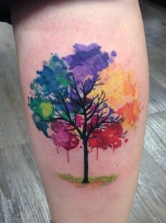 a colorful tree tattoo on the leg