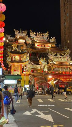 people walking down the street in front of chinese lanterns