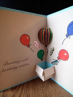 an open birthday card with balloons on it