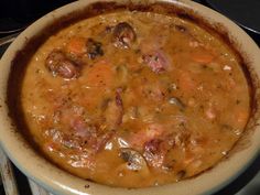 a white bowl filled with soup on top of a stove