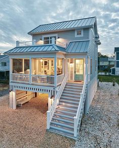 a beach house with stairs leading to the second floor and an upstairs bedroom on top