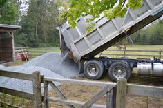 a dump truck parked next to a wooden fence