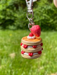 a hand holding a keychain with a stack of pancakes on it