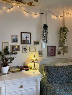 a bedroom with plants and pictures on the wall