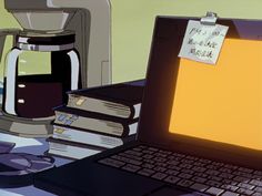 an open laptop computer sitting on top of a desk next to a stack of books