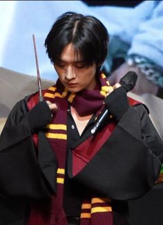 a man holding a pair of scissors in his hands while wearing a harry potter costume