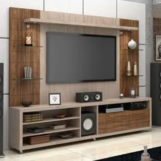 an entertainment center with speakers and a flat screen tv mounted on it's wall