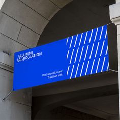 a blue sign hanging from the side of a building next to a doorway with an arch