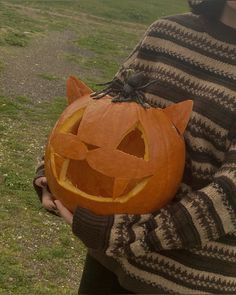 a person holding a carved pumpkin with a cat on it