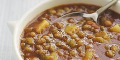 a bowl filled with beans and meat on top of a table