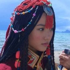 a woman with long black hair holding a cell phone