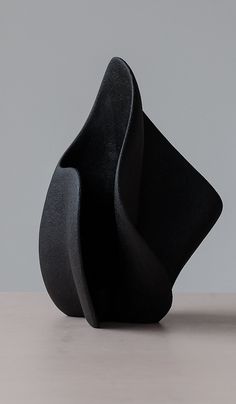 two black sculptures sitting on top of a table