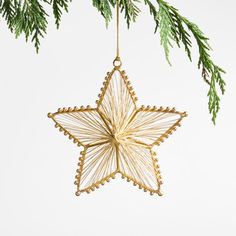 a gold star ornament hanging from a christmas tree