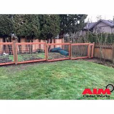 a fenced in area with an animal bed and some grass on the ground next to it