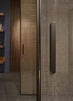 a bathroom with a shower door and shelves on the wall