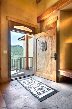 an open door leading to a balcony with a large rug on the floor in front of it