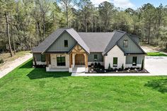 this is an aerial view of the front of a house in the middle of a wooded area